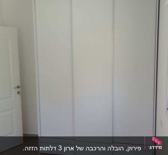 ארון לבן בחדר שינה עם מיטה ודלת פתוחה